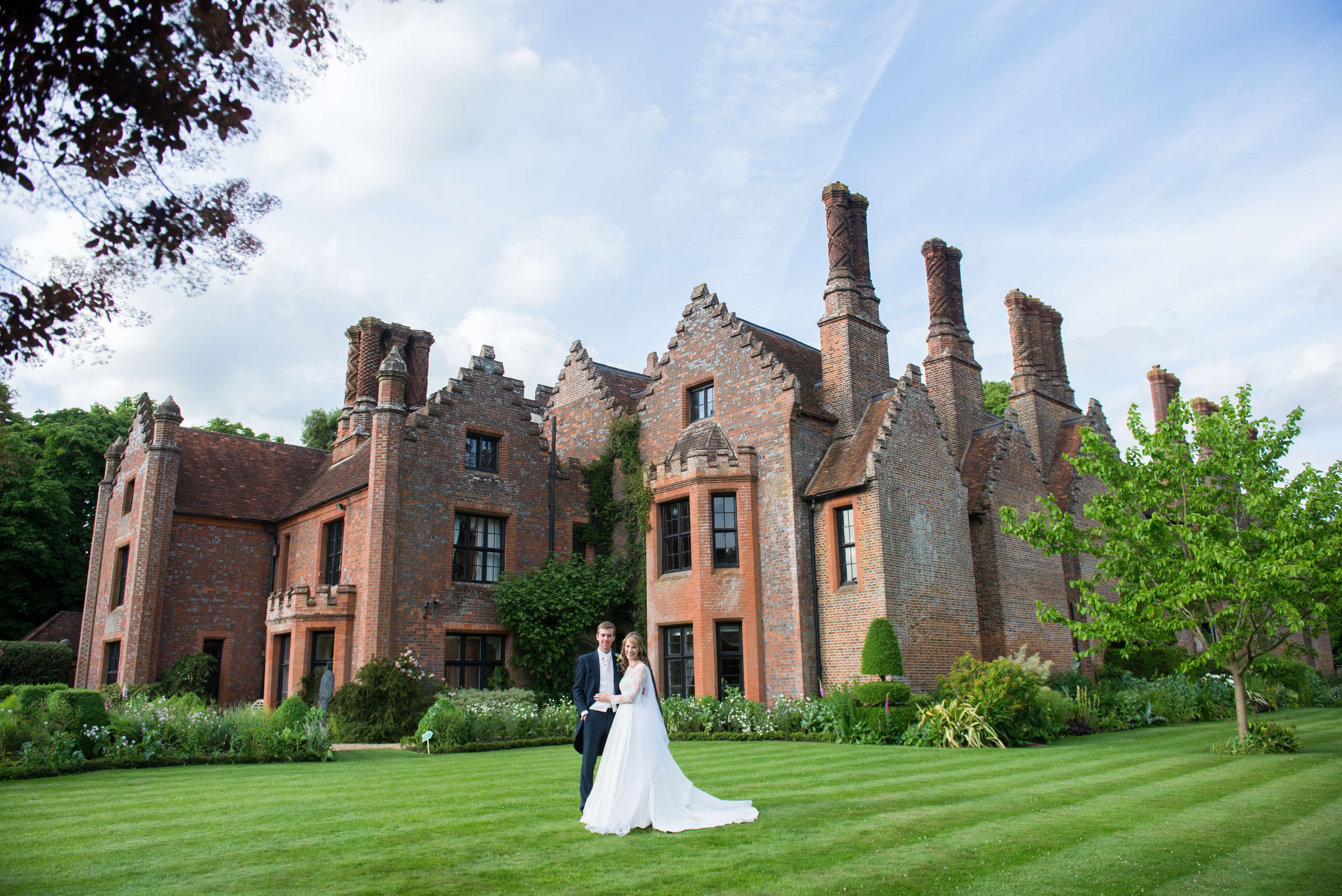A wedding couple standing together on the lawn at Chenies Manor House in Buckinghamshire 